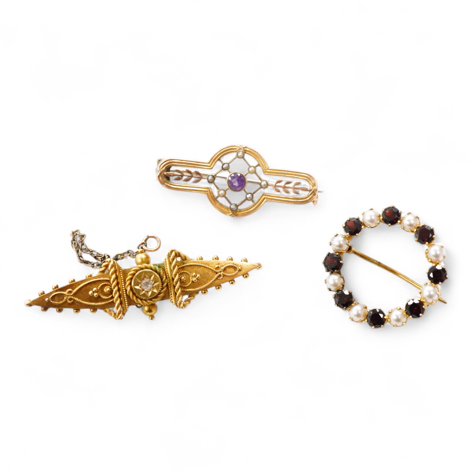 A Victorian 15ct and diamond set navette shaped Etruscan style brooch (lacking pin), 46mm, gross weight 3.5 grams, a 9ct, amethyst and seed pearl set bar brooch and a 9ct, garnet and split pearl set wreath brooch, gross
